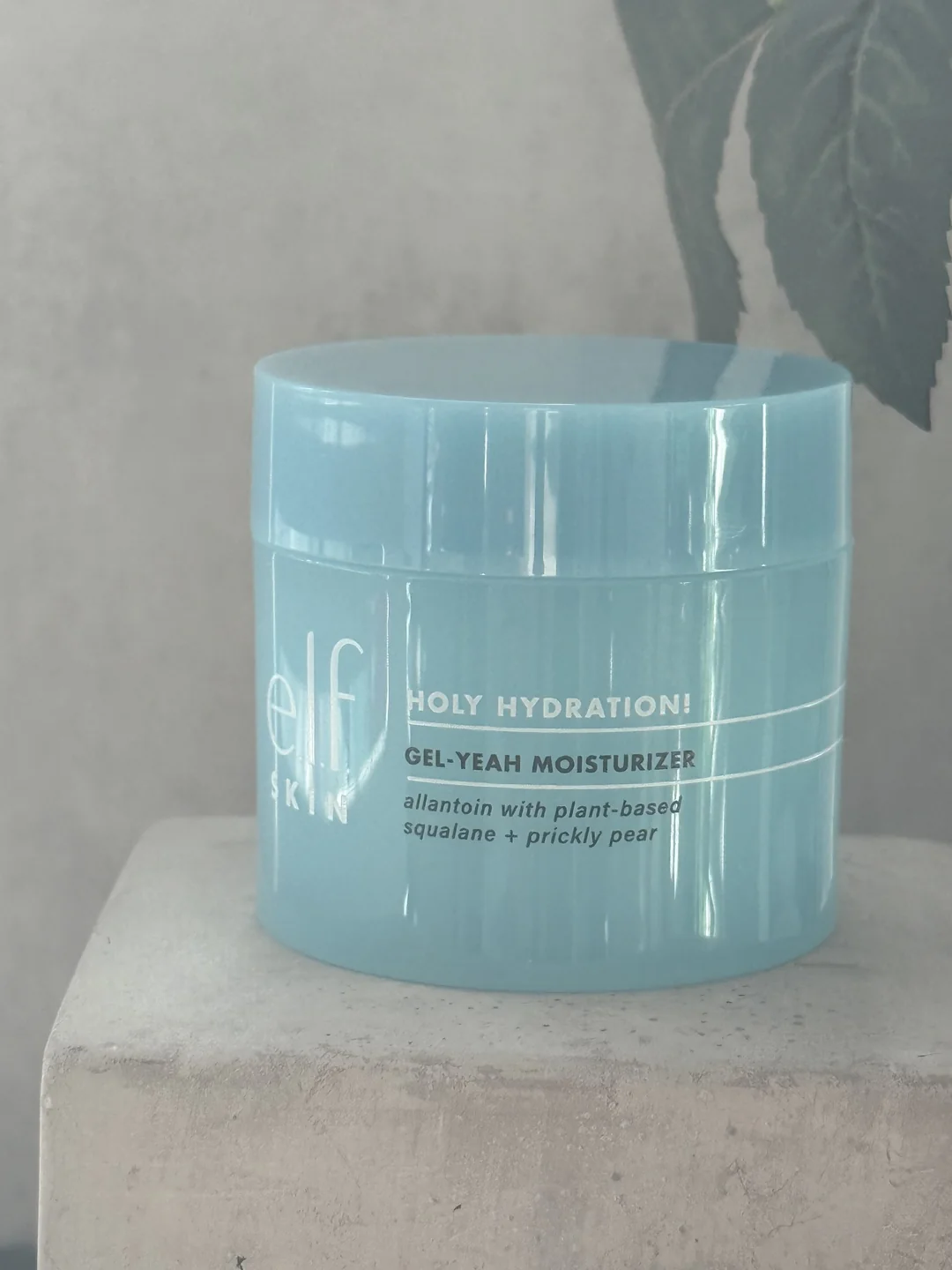 Blue e.l.f. SKIN Holy Hydration Gel-Yeah Moisturizer jar on a light stone pedestal.
