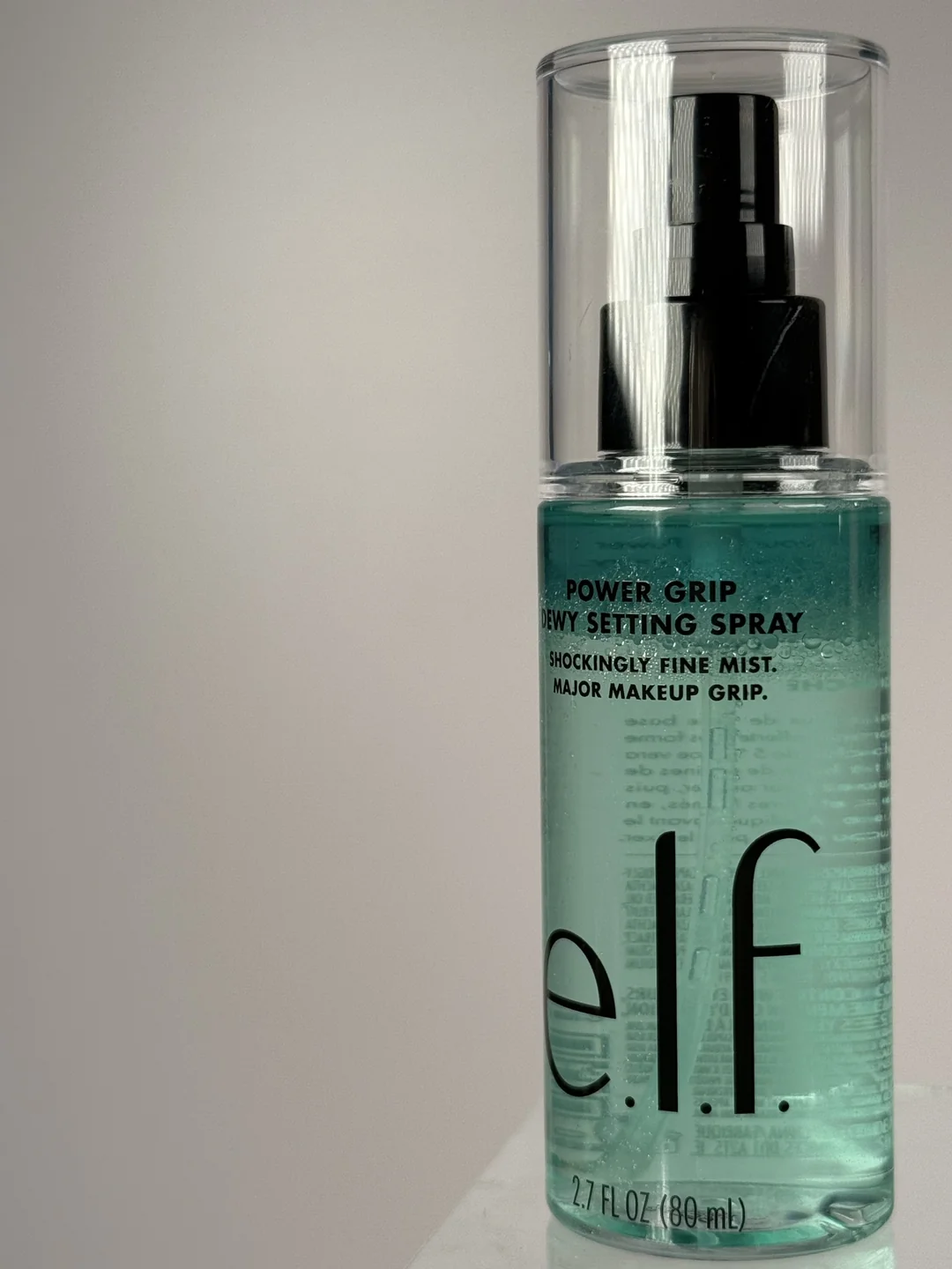 e.l.f. Power Grip Dewy Setting Spray bottle photographed against a softly lit neutral background.