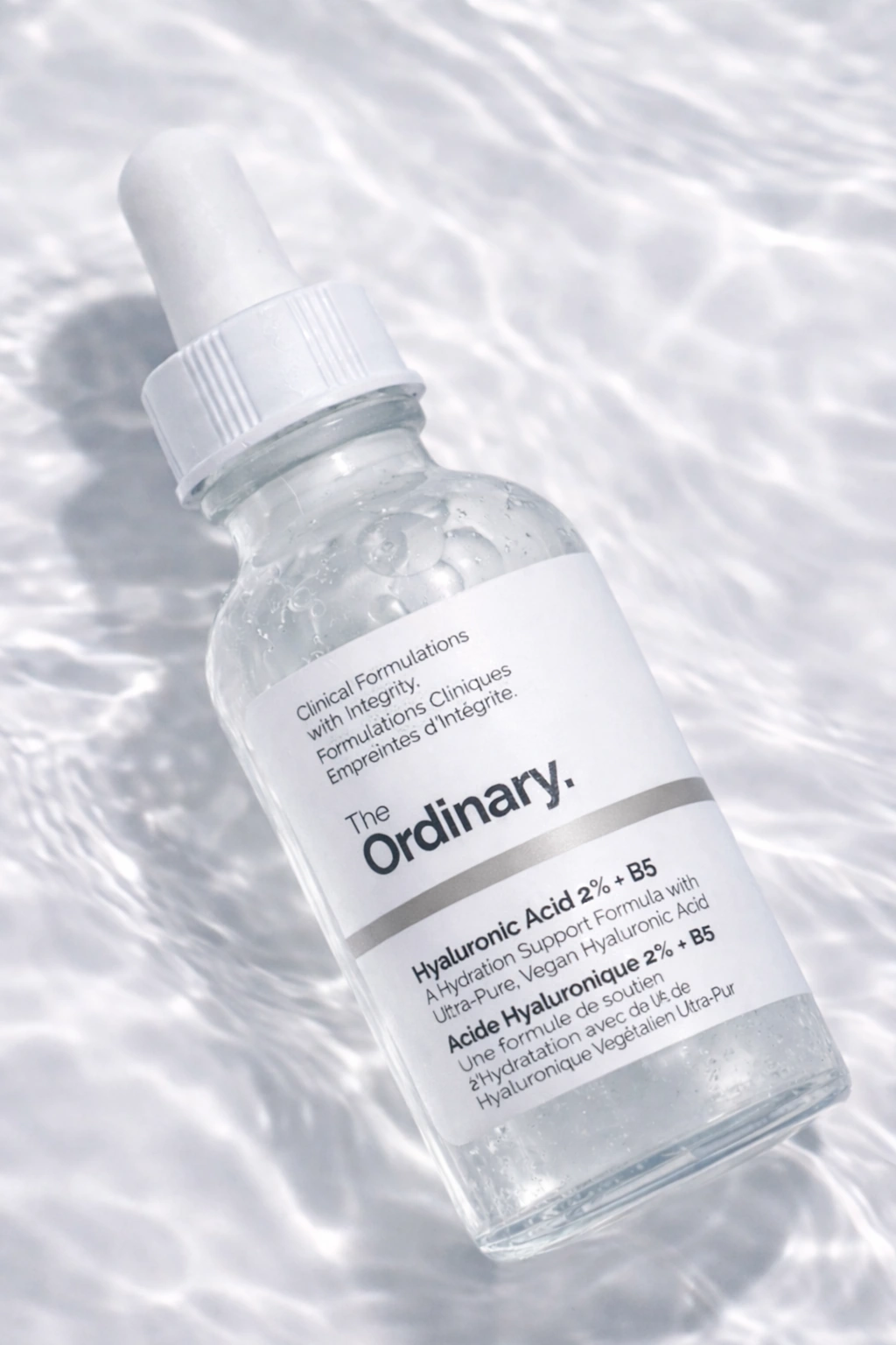 The Ordinary Hyaluronic Acid 2% + B5 serum on a bright water-reflection backdrop.