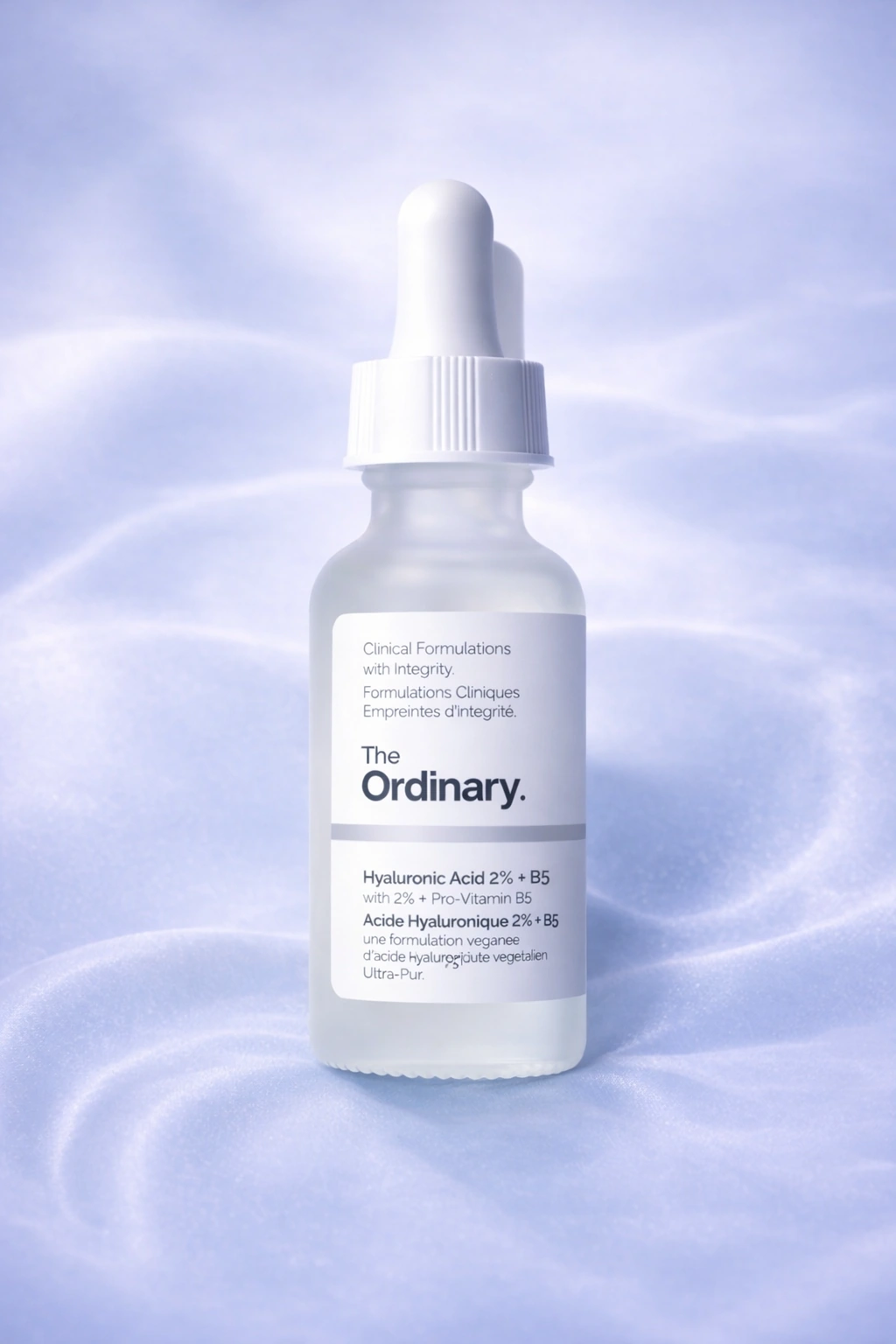 The Ordinary Hyaluronic Acid 2% + B5 serum against a soft lilac rippled backdrop.