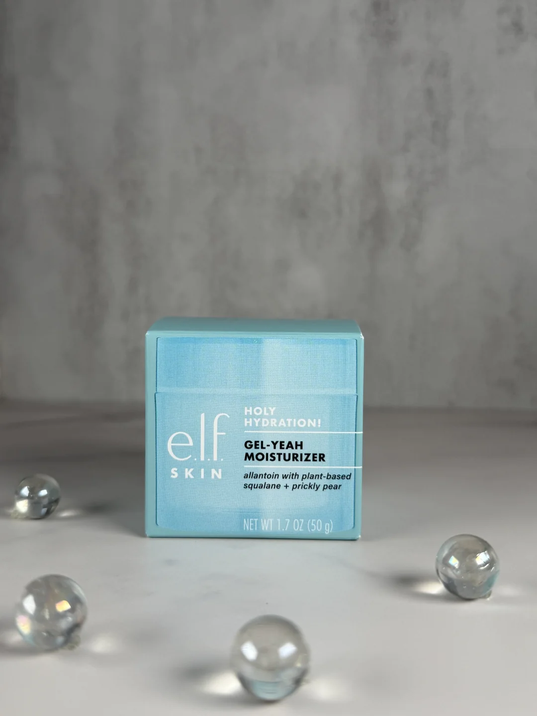 Blue e.l.f. SKIN Holy Hydration Gel-Yeah Moisturizer box styled with glass accent beads.